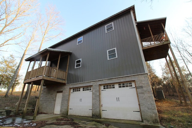 rear view of property featuring a garage and a balcony