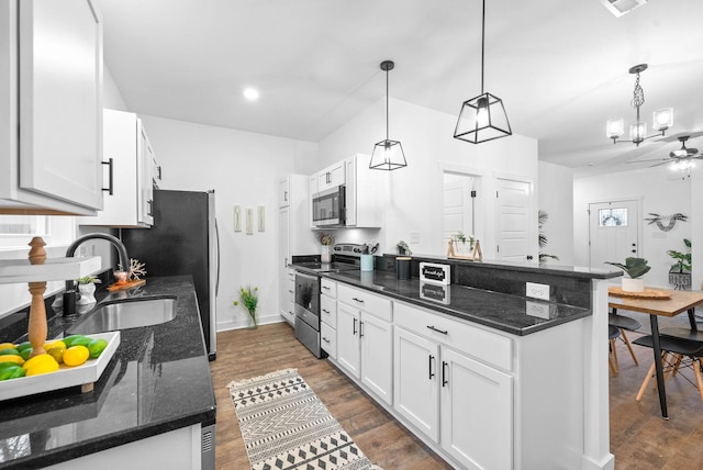 kitchen with pendant lighting, white cabinetry, dark stone countertops, and appliances with stainless steel finishes