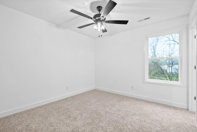 carpeted empty room featuring ceiling fan and a wealth of natural light