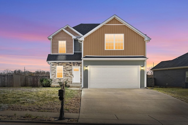 traditional home with an attached garage, fence, cooling unit, stone siding, and driveway