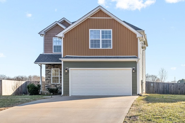 view of front of home featuring a garage, stone siding, driveway, and fence