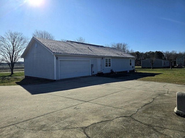 exterior space with a garage, a lawn, and driveway