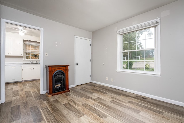 unfurnished living room featuring sink and light wood-type flooring