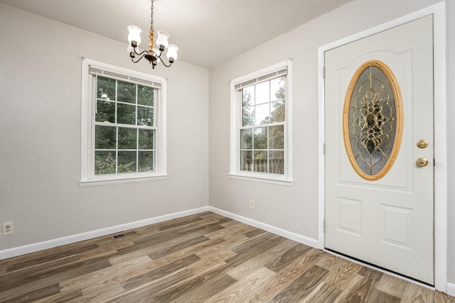 foyer entrance with wood-type flooring and a notable chandelier