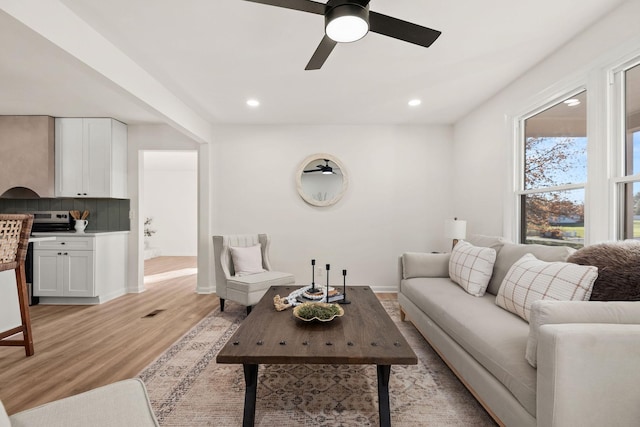 living room featuring ceiling fan and light hardwood / wood-style floors