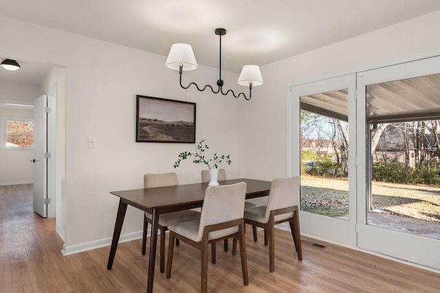 dining space with wood-type flooring