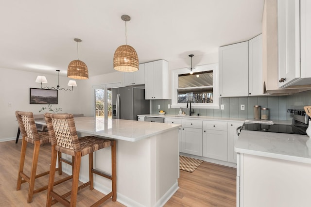 kitchen with hanging light fixtures, white cabinetry, appliances with stainless steel finishes, and a center island