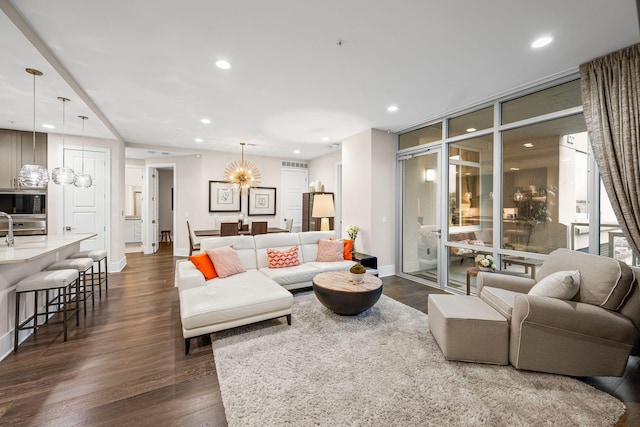 living room featuring a wall of windows, dark hardwood / wood-style floors, and a chandelier