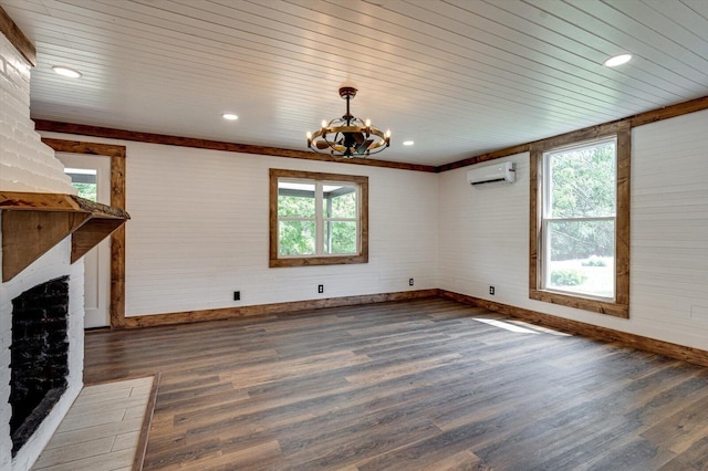 unfurnished living room with a chandelier, a wall mounted air conditioner, dark wood finished floors, and baseboards