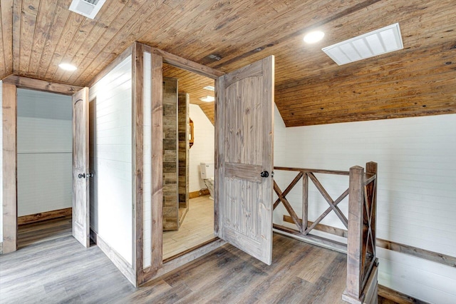 interior space featuring lofted ceiling, wood ceiling, visible vents, and wood finished floors