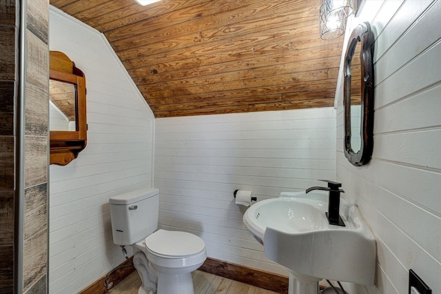 bathroom with lofted ceiling, toilet, wood ceiling, wood walls, and wood finished floors