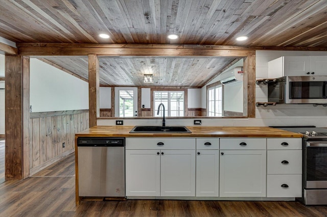 kitchen featuring a sink, wood counters, white cabinetry, appliances with stainless steel finishes, and a wall mounted AC