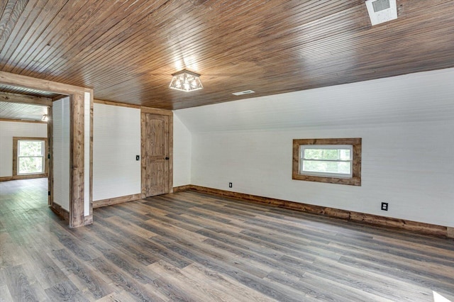 bonus room with dark wood-style floors, vaulted ceiling, visible vents, and baseboards