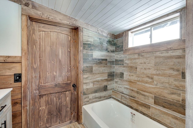 full bath featuring a tub, wood ceiling, and vanity