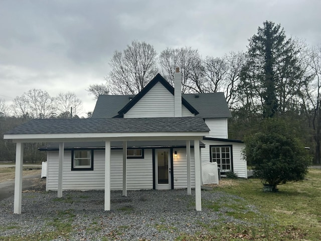 view of front of property with roof with shingles and a chimney