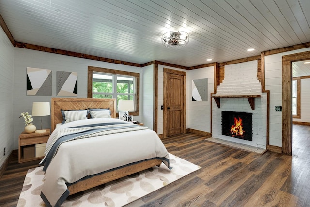 bedroom with wood ceiling, a fireplace, baseboards, and dark wood finished floors