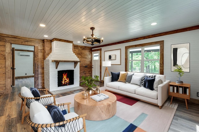 living area featuring recessed lighting, a wall mounted AC, wood ceiling, a brick fireplace, and wood finished floors