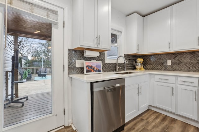 kitchen with sink, white cabinetry, backsplash, dark hardwood / wood-style flooring, and stainless steel dishwasher