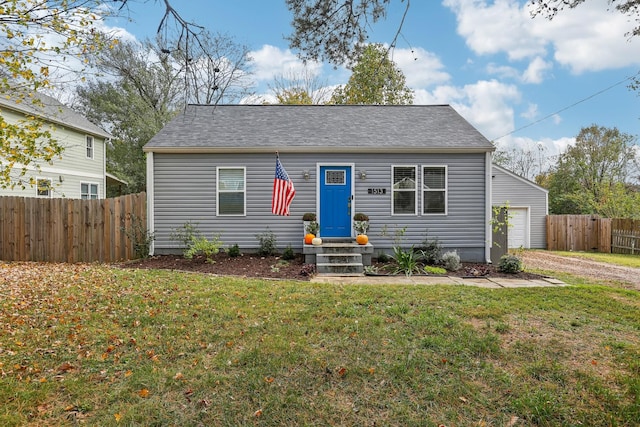 bungalow-style house featuring a garage and a front lawn