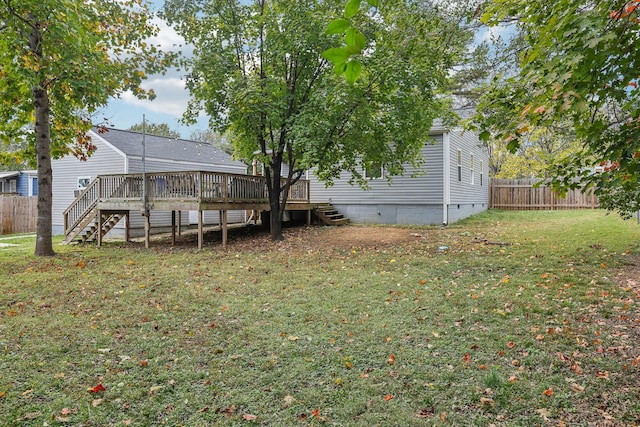 back of property featuring a deck and a lawn