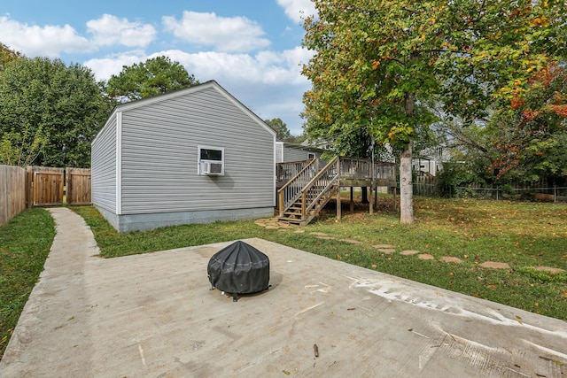 rear view of house featuring a wooden deck, a yard, cooling unit, and a patio area