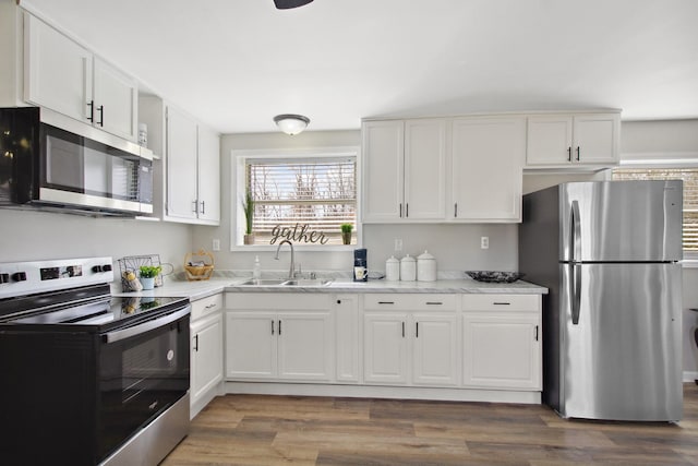 kitchen featuring sink, stainless steel appliances, white cabinetry, and dark wood-type flooring