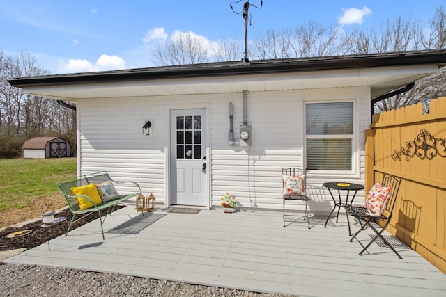 back of house featuring a storage unit and a wooden deck