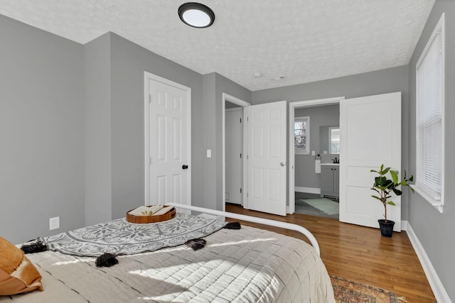 bedroom featuring wood-type flooring, a closet, and a textured ceiling