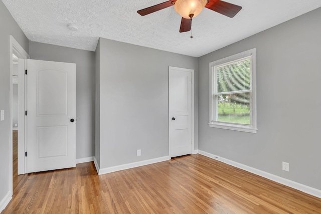 unfurnished bedroom featuring ceiling fan, a textured ceiling, and light hardwood / wood-style flooring