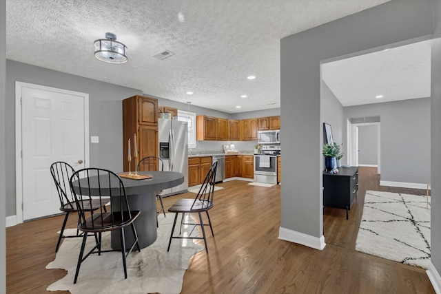 dining area featuring hardwood / wood-style flooring and a textured ceiling