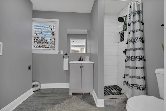 bathroom featuring toilet, vanity, and walk in shower