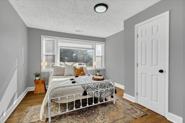 bedroom featuring dark hardwood / wood-style floors and a textured ceiling