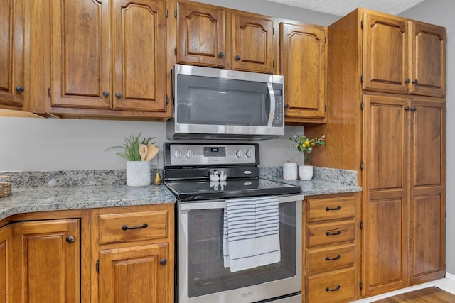 kitchen with stainless steel appliances and light stone countertops