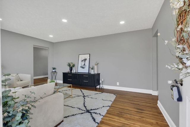 living room with dark hardwood / wood-style floors and a textured ceiling