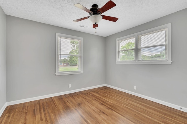 empty room featuring ceiling fan, hardwood / wood-style flooring, and a textured ceiling