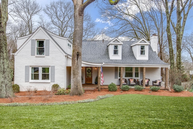 cape cod house featuring a front yard and a porch