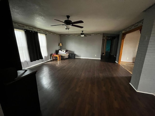 unfurnished living room featuring ceiling fan and dark hardwood / wood-style flooring