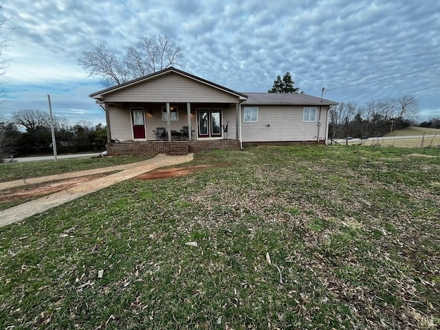 single story home featuring covered porch and a front lawn