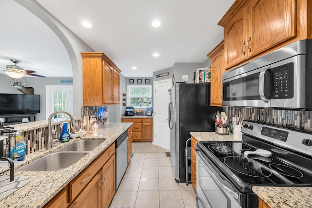 kitchen featuring sink, stainless steel appliances, plenty of natural light, and light tile patterned floors