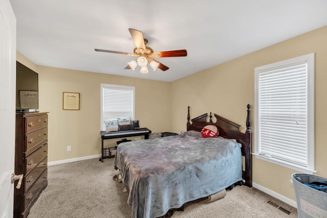 carpeted bedroom with multiple windows and ceiling fan