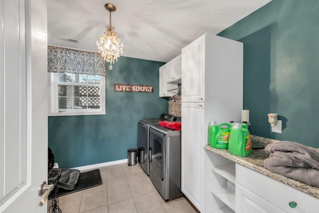 laundry area with a notable chandelier, cabinets, washer and dryer, and light tile patterned floors