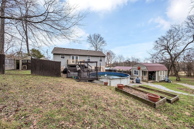 rear view of house with a lawn, a storage unit, and a swimming pool side deck