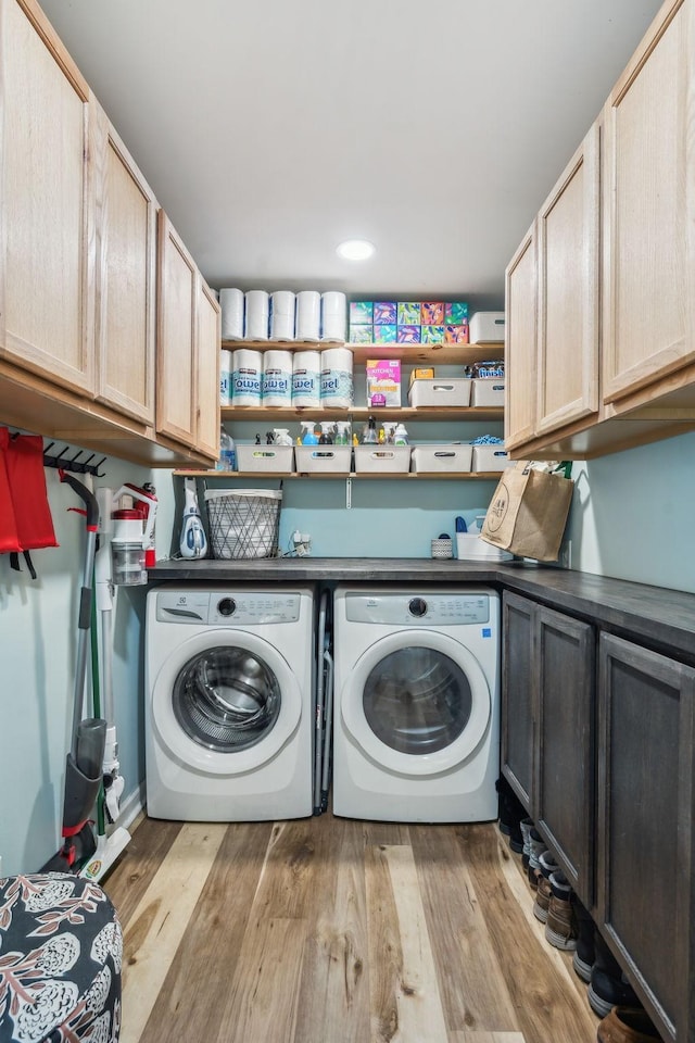 laundry area with cabinets, washer and clothes dryer, and light wood-type flooring