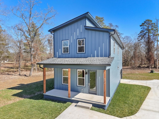 view of front facade featuring a front lawn, board and batten siding, and roof with shingles