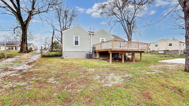 back of property featuring central AC, a deck, and a lawn