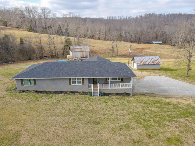 view of front of property with a porch, a garage, an outdoor structure, and a front yard