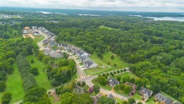 birds eye view of property featuring a wooded view and a water view