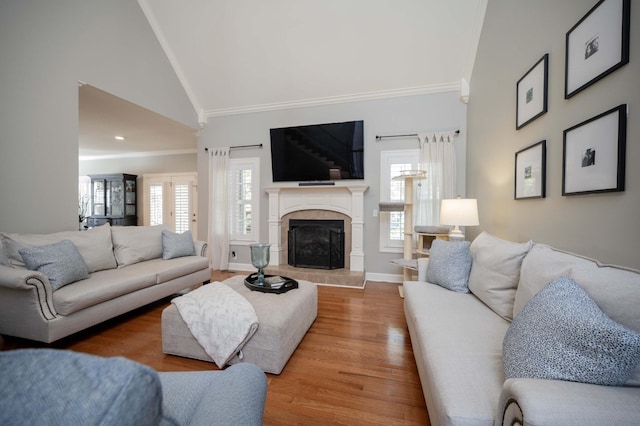 living room with high vaulted ceiling, hardwood / wood-style flooring, plenty of natural light, and ornamental molding