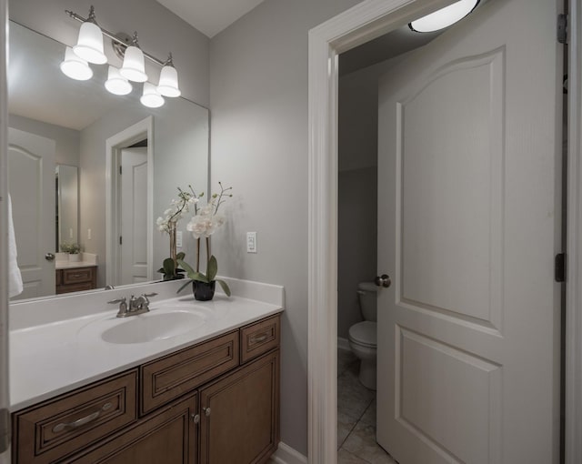 bathroom with tile patterned flooring, vanity, and toilet