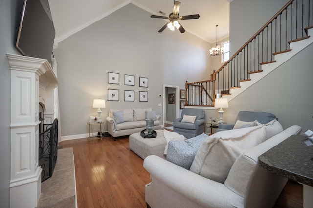 living room featuring hardwood / wood-style flooring, ceiling fan with notable chandelier, and high vaulted ceiling